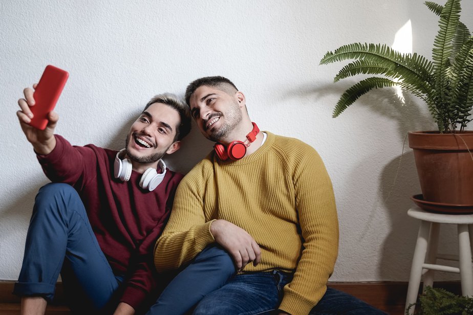 Gay couple streaming online on social media app with mobile phone - Lgbt, technology trendy concept