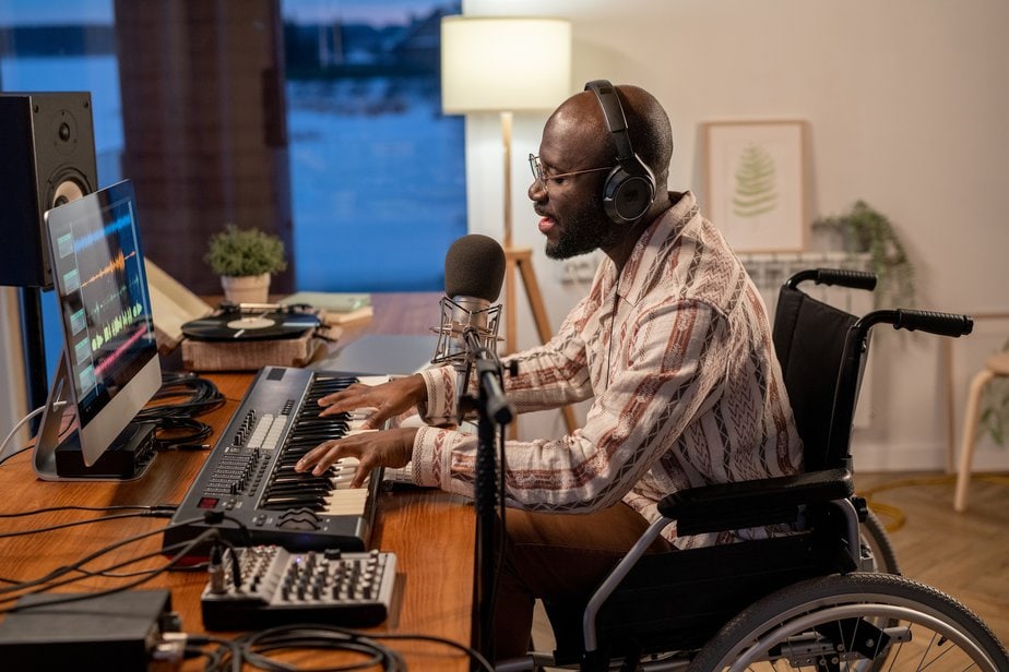 Side view of African American musician in wheelchair recording his songs